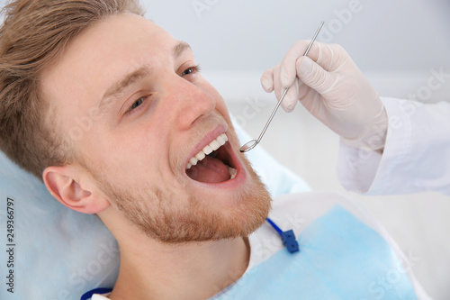 Dentist examining patient s teeth in modern clinic