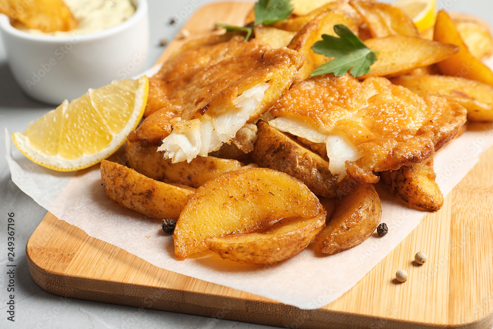 British traditional fish and potato chips on table, closeup British traditional fish and potato chips on table, closeup