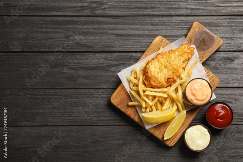 Canvas Print British traditional fish and potato chips on wooden background, top view with sp