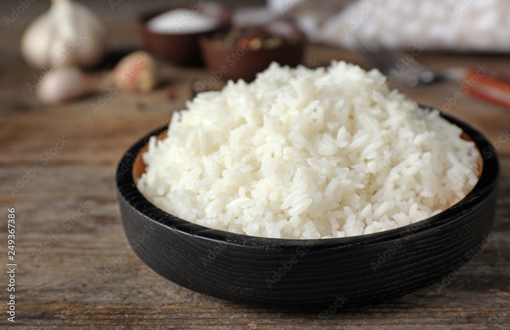 Boiled rice in bowl on wooden table Boiled rice in bowl on wooden table