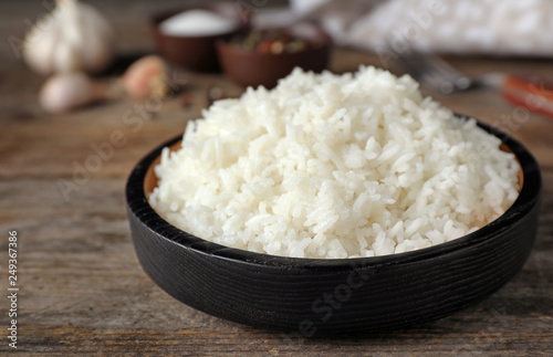 Boiled rice in bowl on wooden table