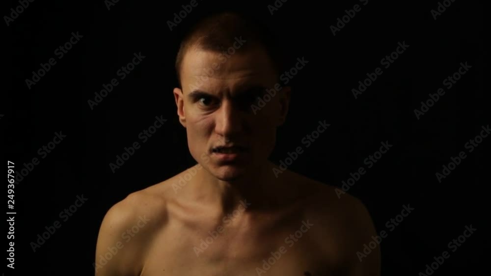 Male portrait on a black background. Expressing anger Male portrait on a black background. Expressing anger