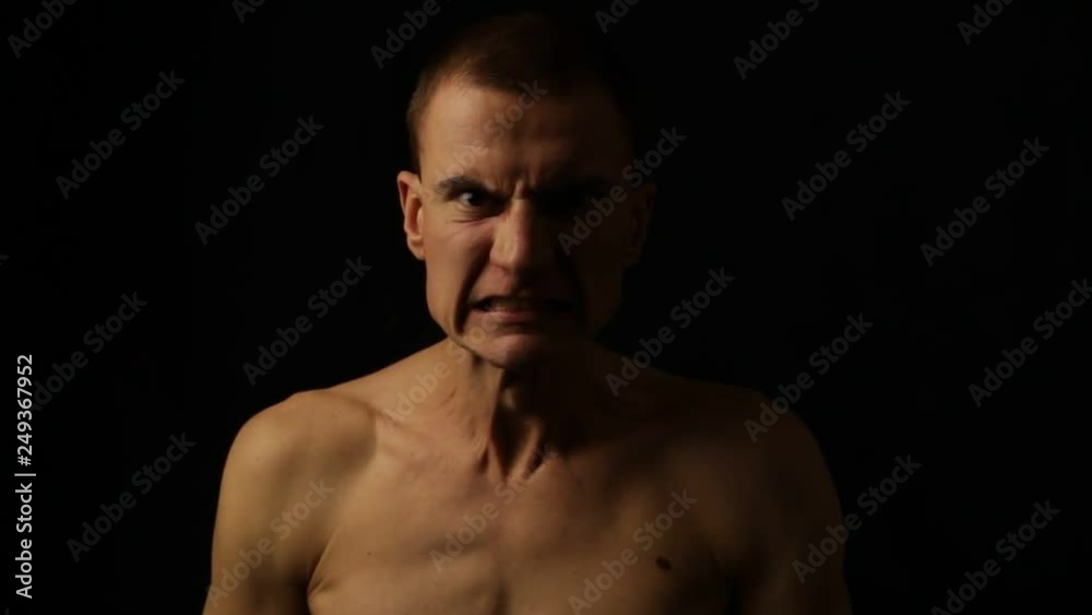Male portrait on a black background. Expressing anger Male portrait on a black background. Expressing anger