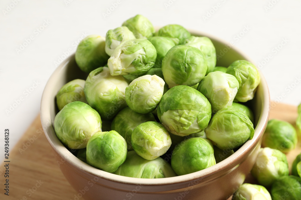 Bowl of fresh Brussels sprouts on wooden board, closeup Bowl of fresh Brussels sprouts on wooden board, closeup