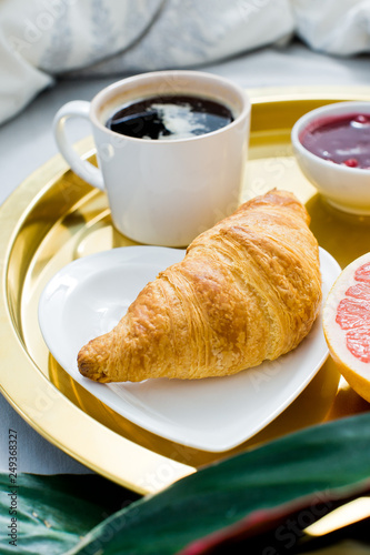 Classic Breakfast in bed  hotel service. Coffee  jam  croissant  orange juice  grapefruit  lychee. Top view  light background