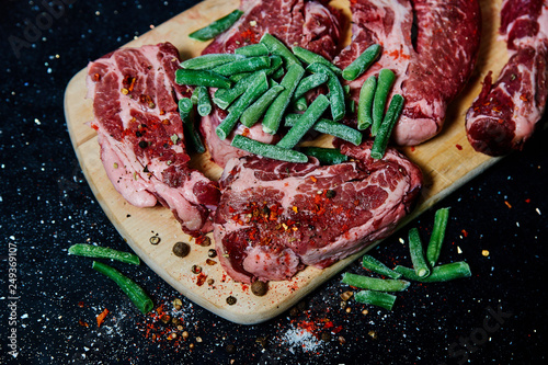 Fresh raw meat pork neck on wooden Board on black table photo