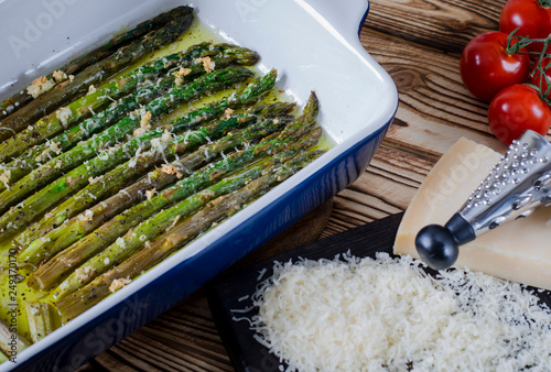 Green juicy asparagus is in ceramic form in olive oil