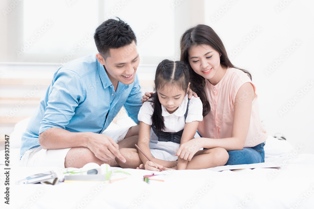 Happy family on white bed in the bedroom at home. Mother, Father and the children playing at home on the bed. The good family health of three people. Happy family on white bed in the bedroom at home. Mother, Father and the children playing at home on the bed. The good family health of three people.