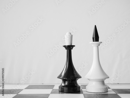 concept of interracial couple with white man and black woman. chessman king and queen on chessboard photo