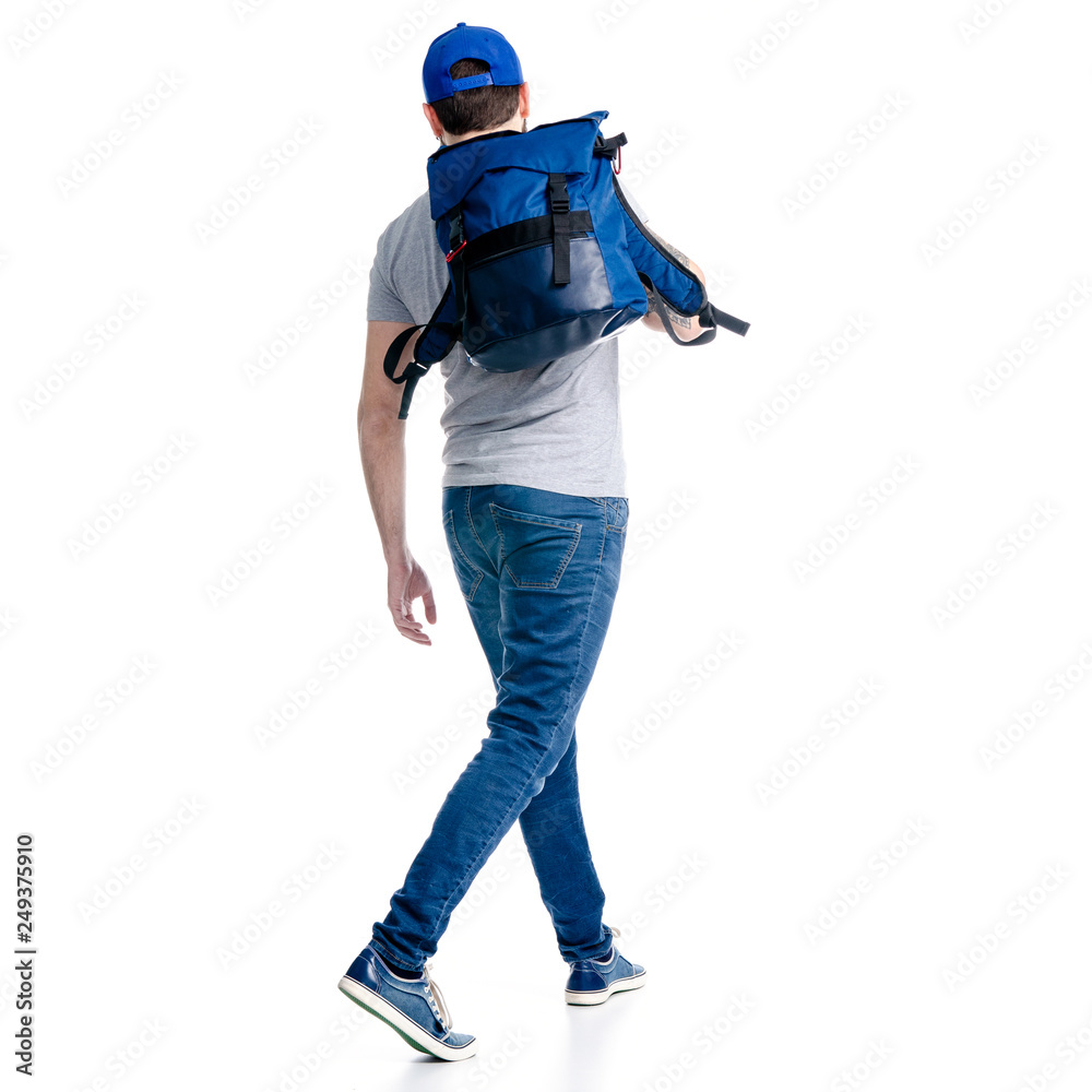 A man tourist in jeans and cap, blue backpack goes walking on white background isolation, back view A man tourist in jeans and cap, blue backpack goes walking on white background isolation, back view