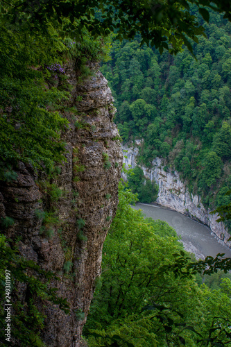 отвесная скала на фоне реки и лесом в Краснодарском крае