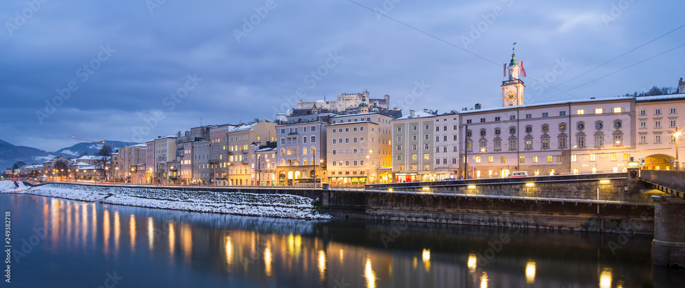 Panoramic view to river side with buildings in winter twilight in Salzburg in Austria