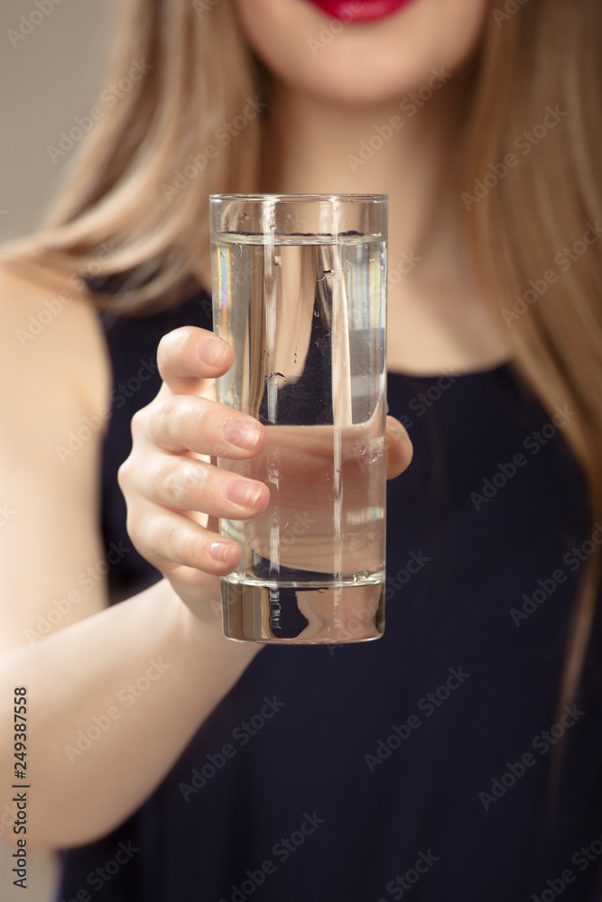 woman's hand holding a glass of water. Close-up of a glass. Nutrition concept woman's hand holding a glass of water. Close-up of a glass. Nutrition concept