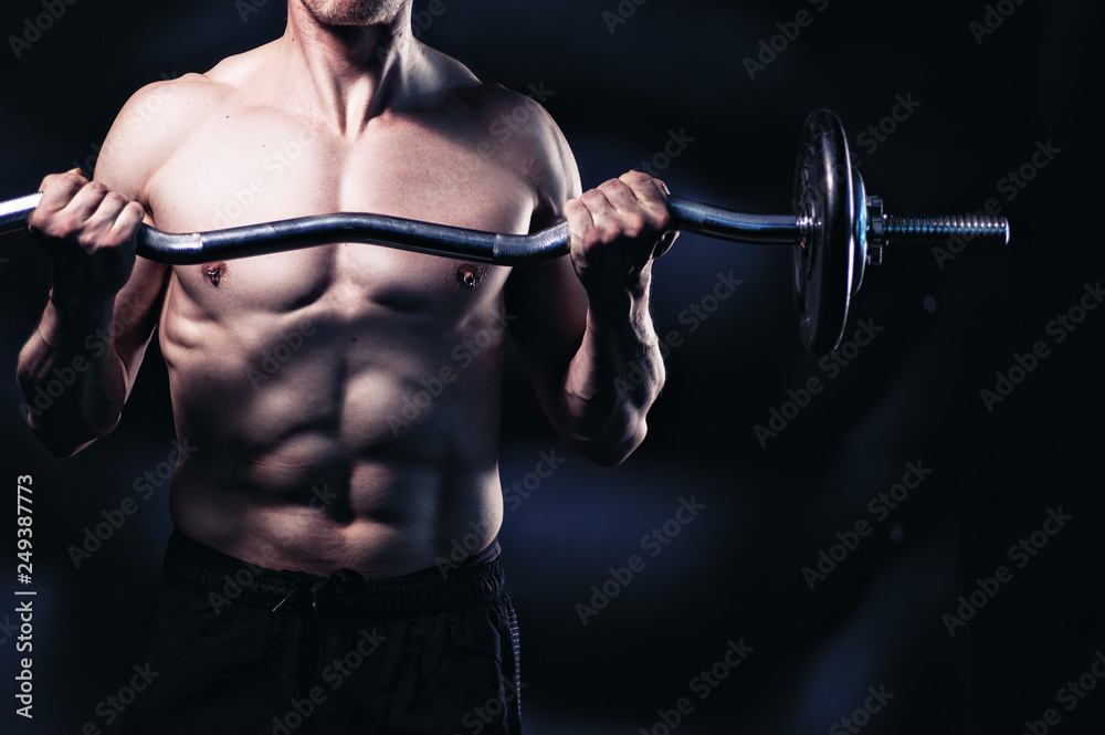 Strong and muscular guy lifting weights. Biceps training. Gym concept. Edgy edit style. Strong and muscular guy lifting weights. Biceps training. Gym concept. Edgy edit style.