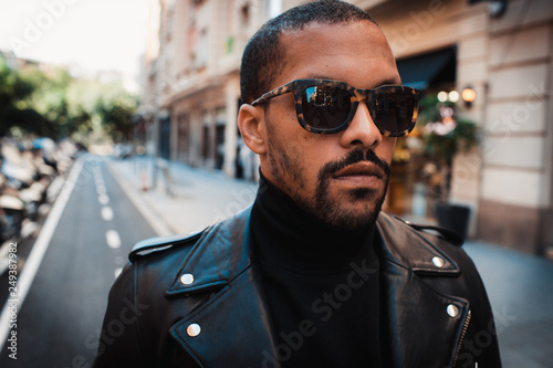 Confident african american man wearing on sunglasses and black leather jacket outdoor. Street wear fashion black man. Closeup photo
