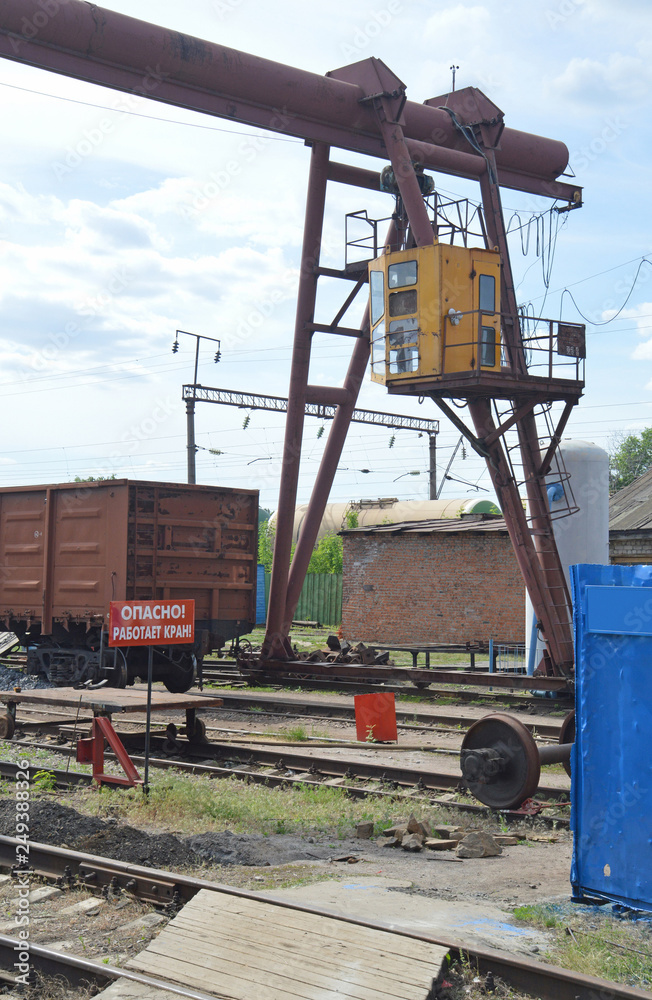 Gantry crane on-site cutting of scrap metal at the railway station. The plate with the inscription 