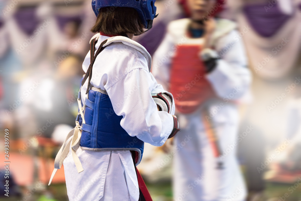 Moment of Taekwondo Kids in the stadiums. Athlete to strike an opponent during the tournament taekwondo kids. Add film filter and effect zoom for movement feeling. Moment of Taekwondo Kids in the stadiums. Athlete to strike an opponent during the tournament taekwondo kids. Add film filter and effect zoom for movement feeling.