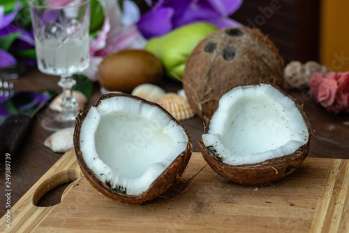 Two halves of ripe freshness coconut shell on dark wooden table