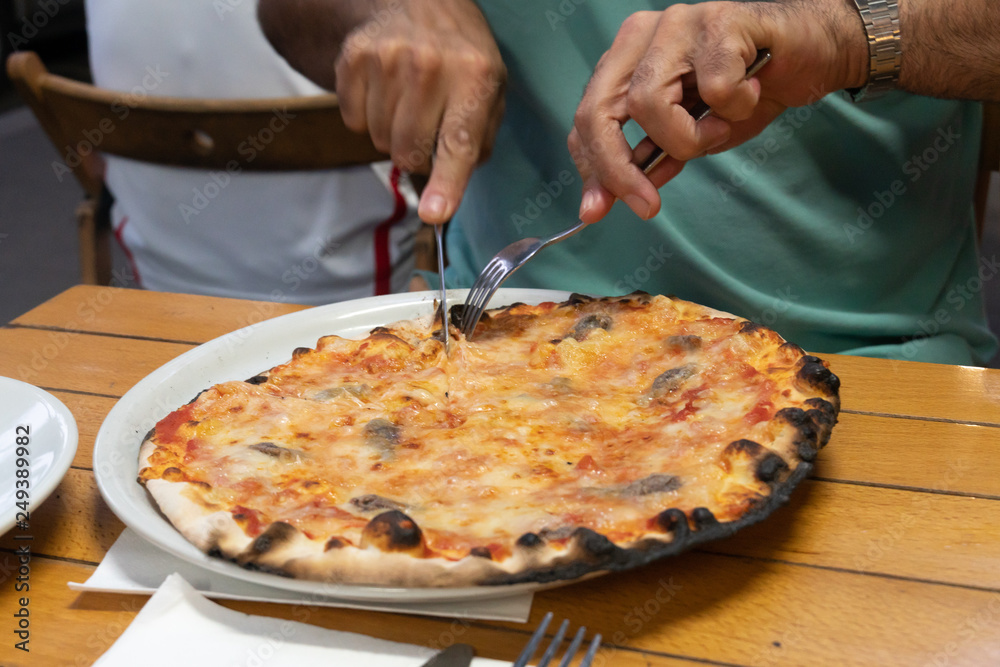 Eating a traditional Italian pizza. Selective focus