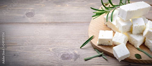Panel kuchenny z motywem Feta cheese with rosemary on wood background. Top view with space for text
