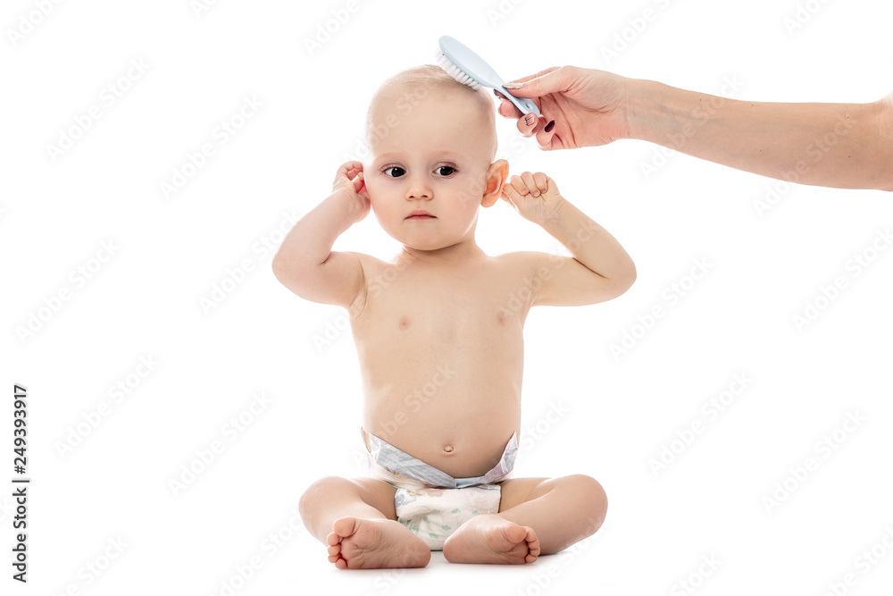 Mother hand combing hair Baby boy, isolated on white background. Baby care, healthcare concept, hygiene Mother hand combing hair Baby boy, isolated on white background. Baby care, healthcare concept, hygiene