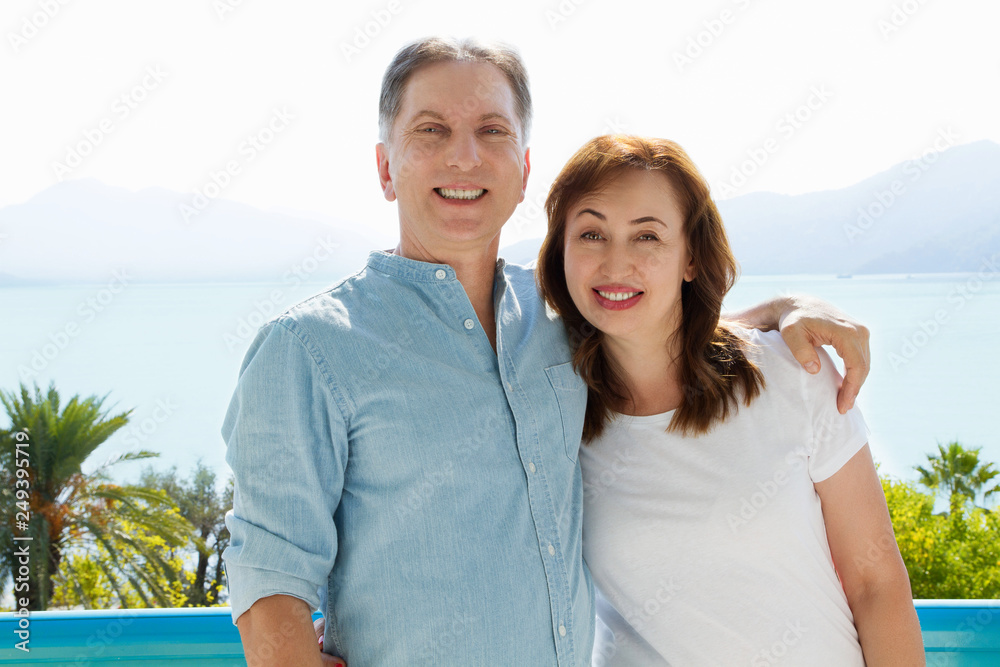 Obraz premium Summer white t shirt template. Happy middle aged family couple at vacation. Beach and holiday concept. Copy space and mock up