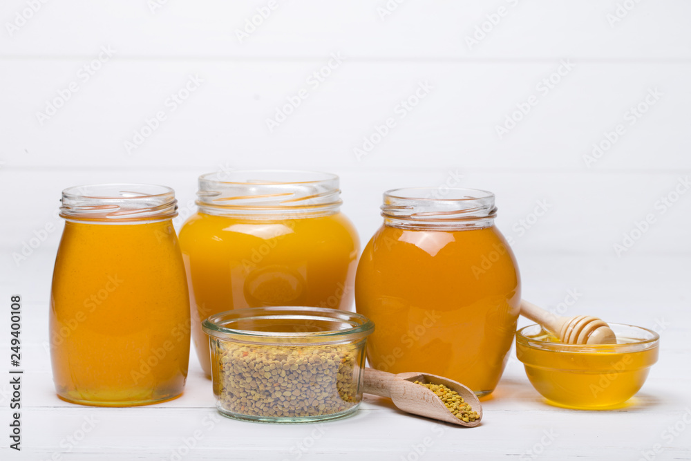 honey dipper and honey in jar on white background honey dipper and honey in jar on white background