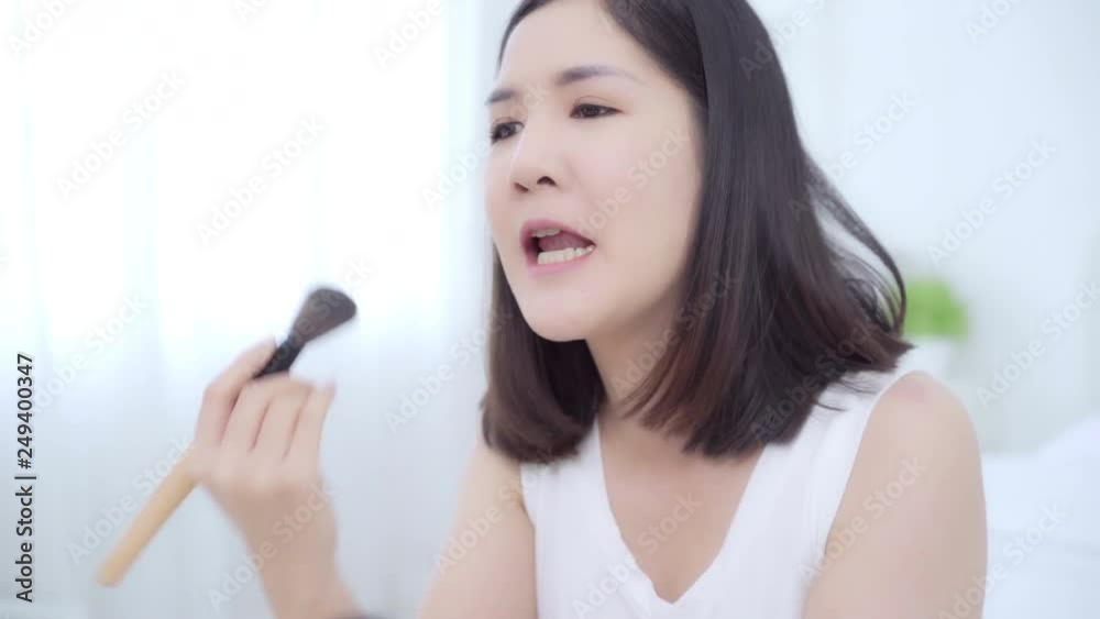 Beauty blogger present beauty cosmetics sitting in front camera for recording video. Happy beautiful young Asian woman use cosmetics review make up tutorial broadcast live video to social network. Beauty blogger present beauty cosmetics sitting in front camera for recording video. Happy beautiful young Asian woman use cosmetics review make up tutorial broadcast live video to social network.