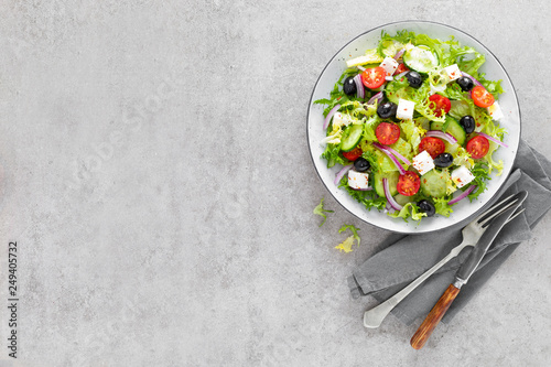 Vegetable salad with fresh cucumber, tomato, olive, onion, lettuce and feta cheese. Healthy food. Top view