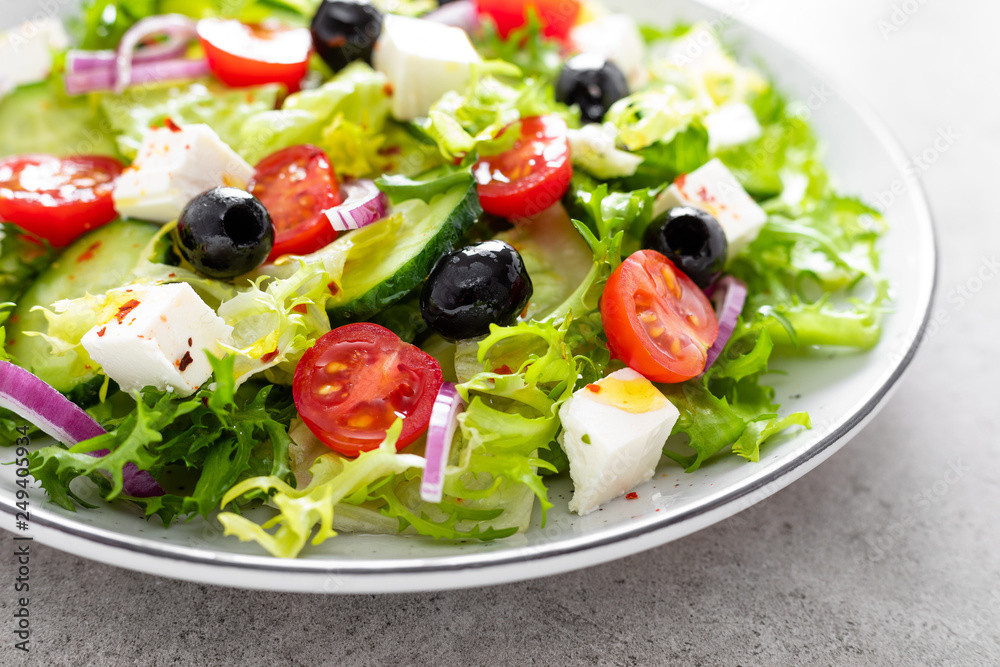 Vegetable salad with fresh cucumber, tomato, olive, onion, lettuce and feta cheese. Healthy food
