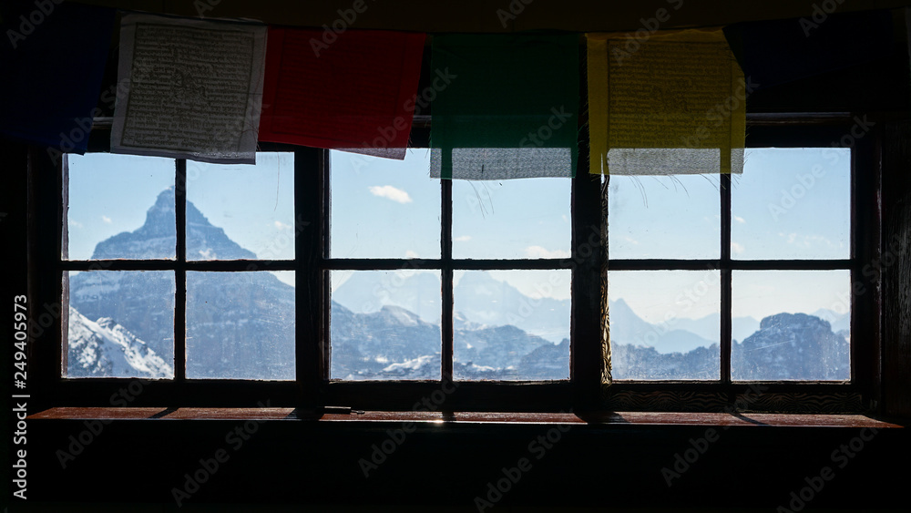 Fototapeta premium Prayer flags above a window in a climbing hut in the Canadian Rockies