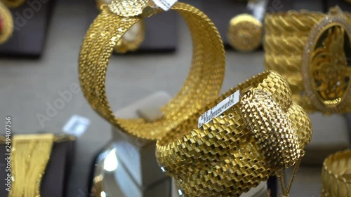 Two gold rings rotate on a stand on the counter of a jewelry store. HD video
