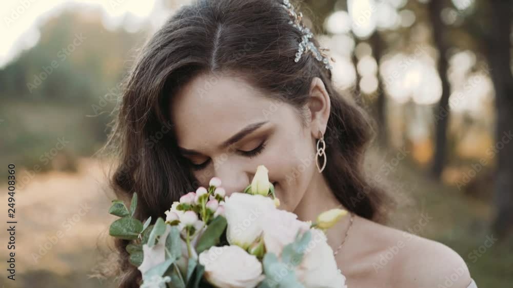 Portrait of attractive bride smiling and sniffing flowers at camera Portrait of attractive bride smiling and sniffing flowers at camera