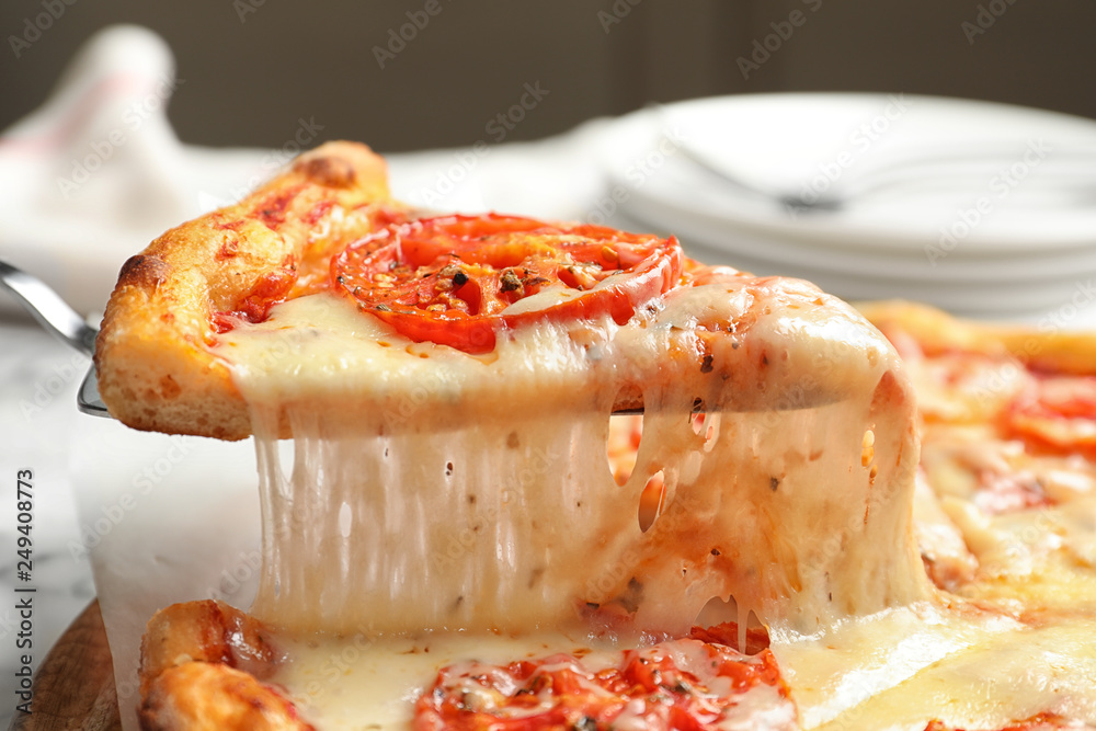 Taking slice of hot cheese pizza Margherita on table, closeup Taking slice of hot cheese pizza Margherita on table, closeup