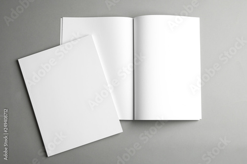Open and closed blank brochures on grey background, top view. Mock up for design photo