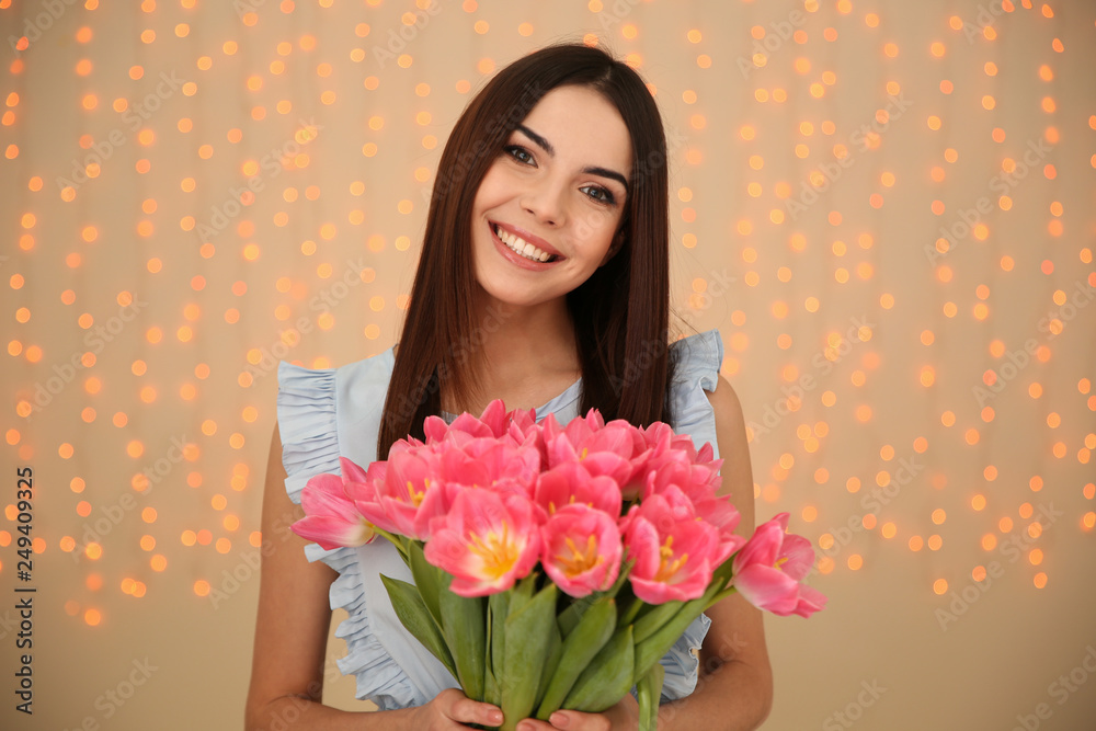 Portrait of smiling young girl with beautiful tulips on blurred background. International Women's Day Portrait of smiling young girl with beautiful tulips on blurred background. International Women's Day