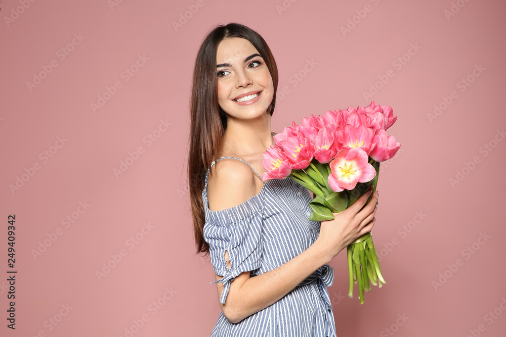 Portrait of beautiful smiling girl with spring tulips on pink background. International Women's Day Portrait of beautiful smiling girl with spring tulips on pink background. International Women's Day