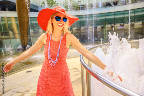 Fountain of Wealth at Suntec Tower, the biggest fountain in Singapore. Lifestyle woman walk and touch water of fountain to get luck. Blonde caucasian tourist enjoying at largest fountain in the world. photo