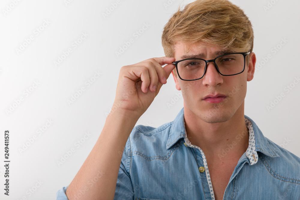 Attractive young man with eyeglasses in studio looking at camera Attractive young man with eyeglasses in studio looking at camera