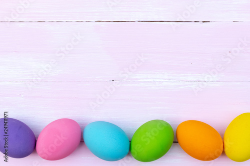 Easter eggs concept. Happy Easter Day. Row Easter eggs on bright pink wooden background.