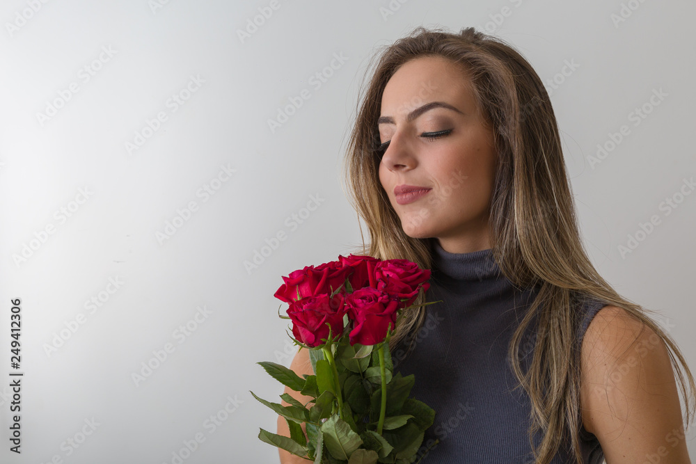 Spring holidays, International Women's Day, 8 March celebration. Young pretty woman holding bouquet of red roses Spring holidays, International Women's Day, 8 March celebration. Young pretty woman holding bouquet of red roses