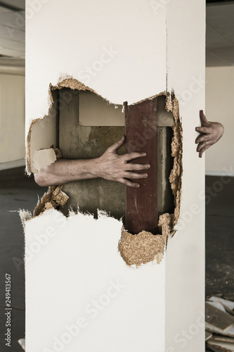 Man's hand around broken pillar