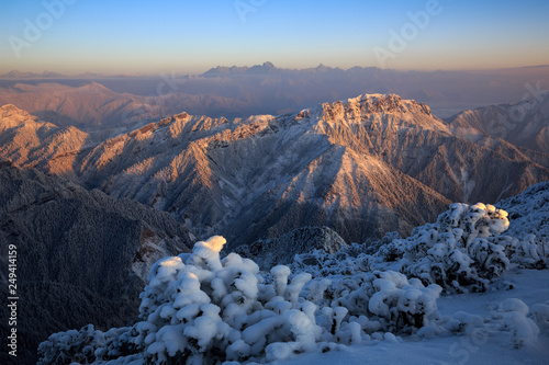 Dawn, Sunrise above the clouds - Niubeishan Landscape, Cattle Back Mountain, Sichuan Province China. Snow mountains, Ice Frost and Rime. Frozen Winter Landscape, Frigid Cold Atmosphere. Sea of Clouds photo