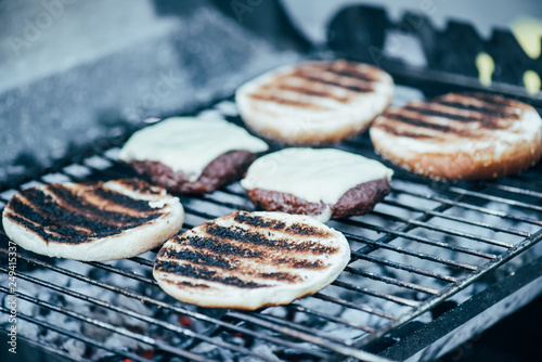 selective focus of delicious fresh burgers ingredients with crust grilling on barbecue grid