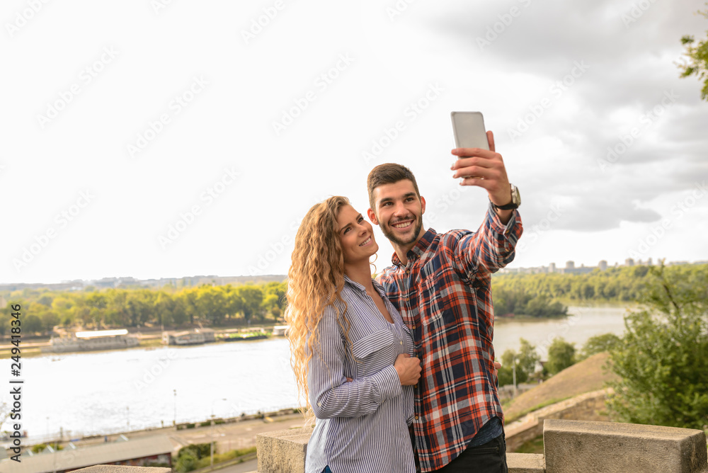 Young attractive couple taking selfie near the river