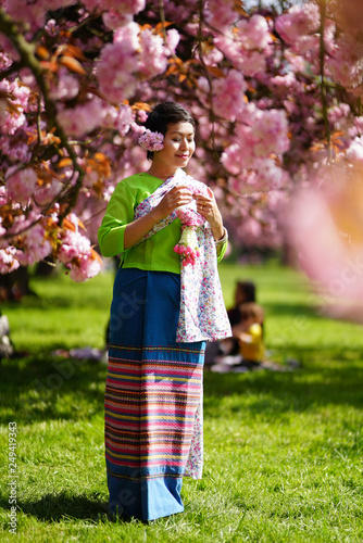 Femme en habit traditionnel thaï et fleurs de sakura