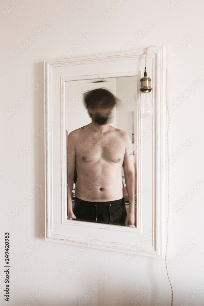 Un homme torse nu dans le miroir Photos | Adobe Stock