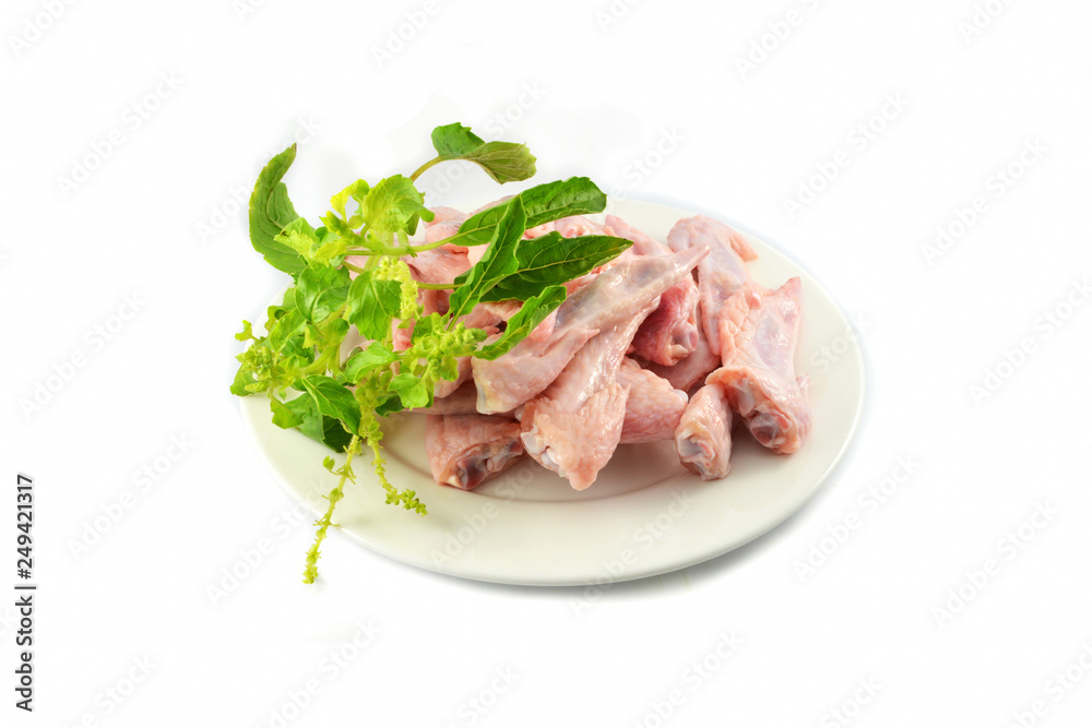Fresh raw chicken wing on plate and holy basil isolated on white background