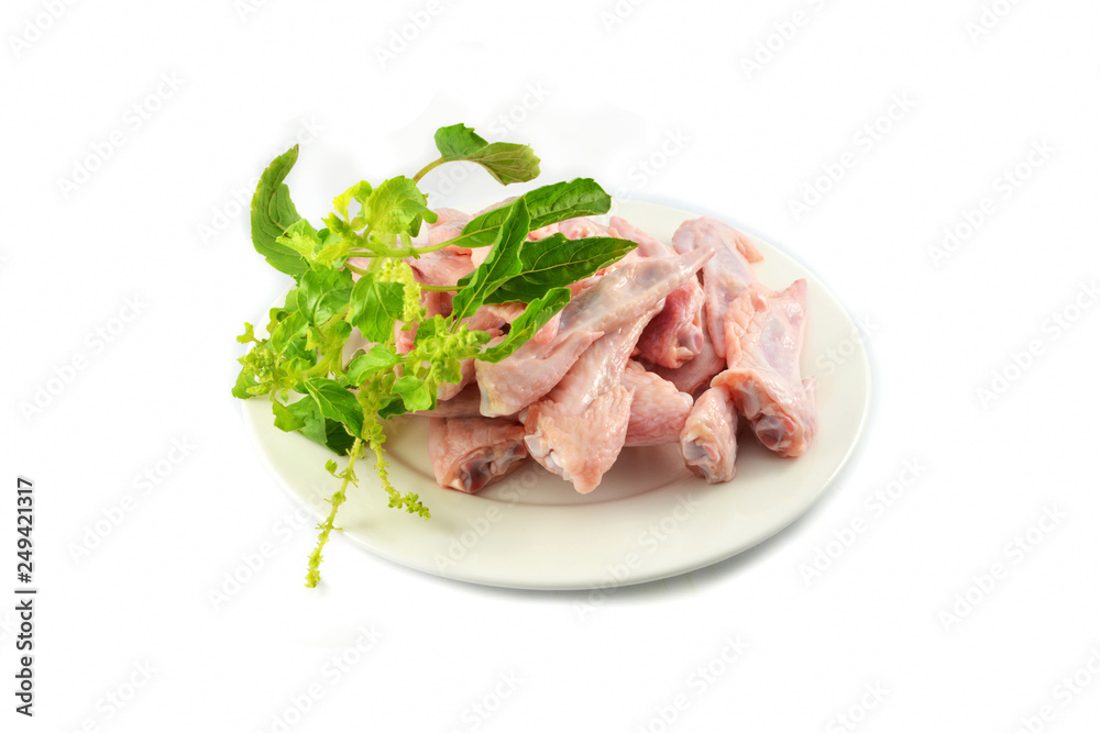 Fresh raw chicken wing on plate and holy basil isolated on white background Fresh raw chicken wing on plate and holy basil isolated on white background