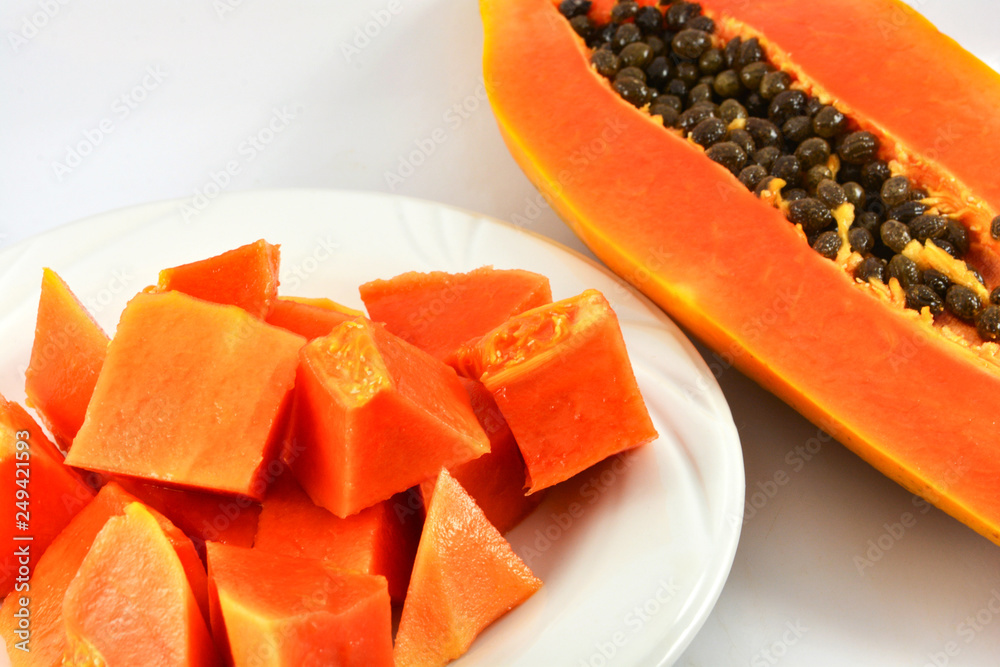 papaya slice on plate and ripe papaya fruit cut half dissect on white background papaya slice on plate and ripe papaya fruit cut half dissect on white background